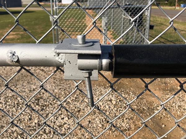 That's an anchor bolt, flipped upside down and pressed into service as the operator's arm pin. The opener kit comes with the right brackets and pins in the box. So where'd they go?