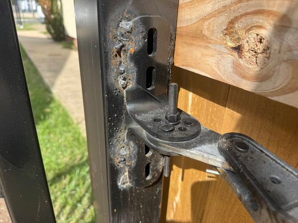 Bubbled-up welds holding an operator arm bracket on, and it was already rusting. We got called out to fix it a few months after the install, once the original installer quit answering the customer's calls.