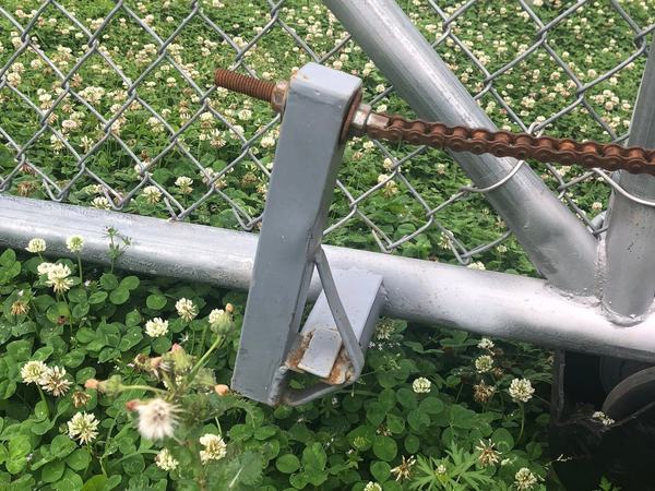 Somebody put in a lot of work just to avoid using a chain breaker and the right bracket. Instead we got a homemade bracket, a rusty threaded rod, and a slide gate chain hanging on for dear life.